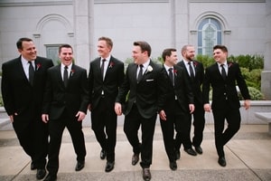 Groom with white boutonniere and groomsmen with red boutonnieres