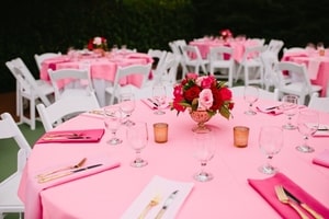 Some guest tables at wedding dinner were round with pink tablecloths and pink and red rose centerpieces