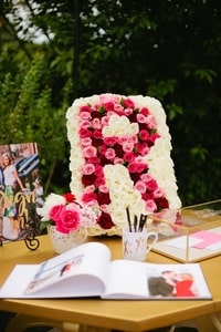 Red and pink roses in a bed of white roses to create a large <em>R</em> for the couple
