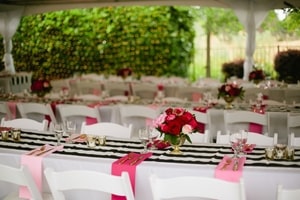 Long tables at wedding reception had black and white runners with pink and red cloth napkins